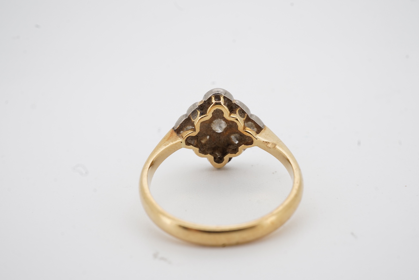 A yellow metal and nine stone millegrain set diamond cluster ring, of diamond form, size M, gross weight 2.9 grams.
